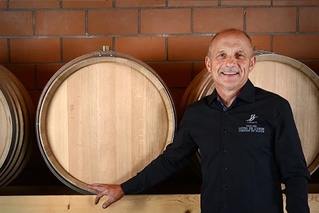 Olivier Chautems devant des barriques dans la cave du Domaine des Dumières à Champvent.